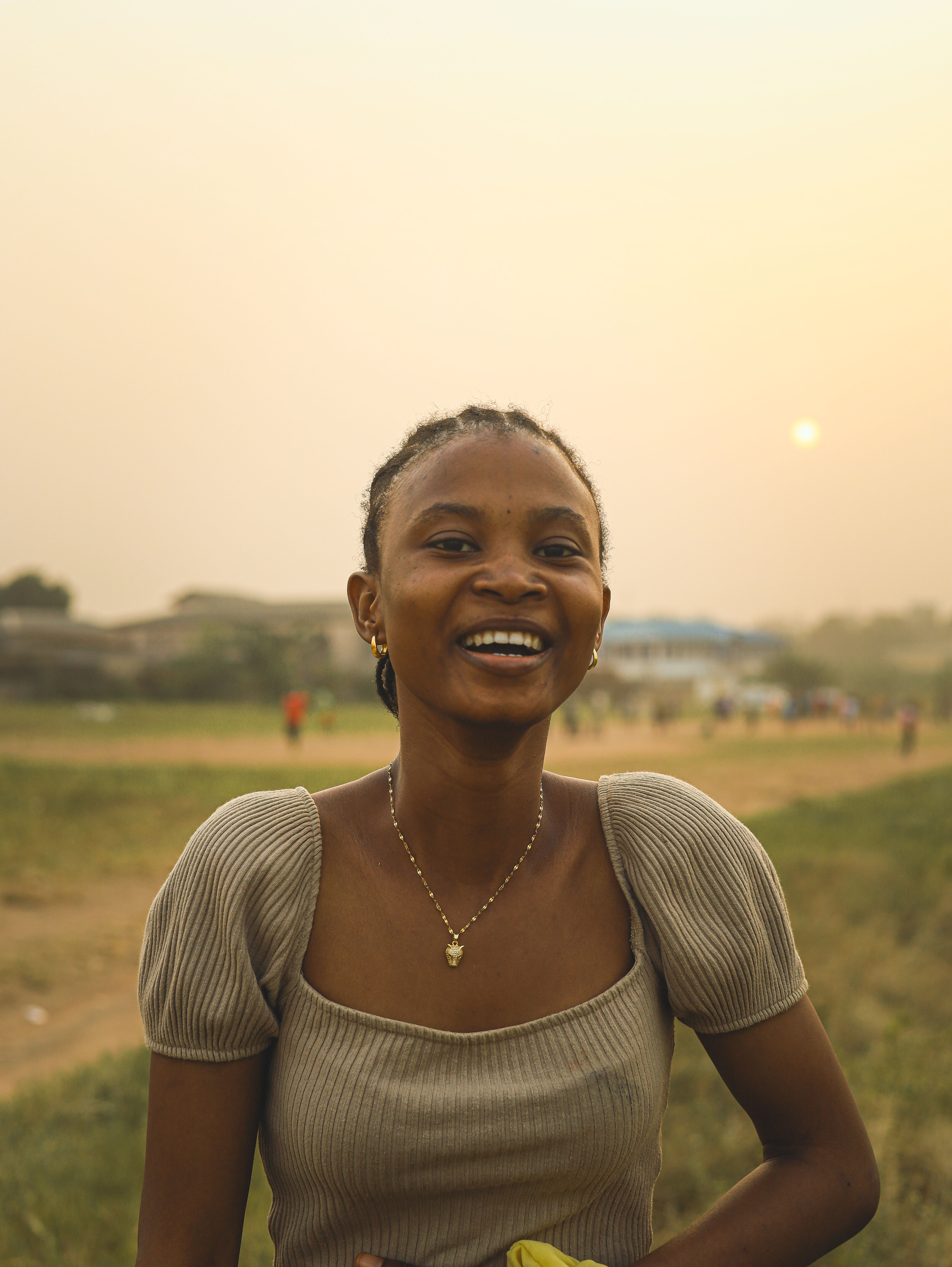 Smiling Woman in Outdoor Setting at Sunset · Free Stock Photo