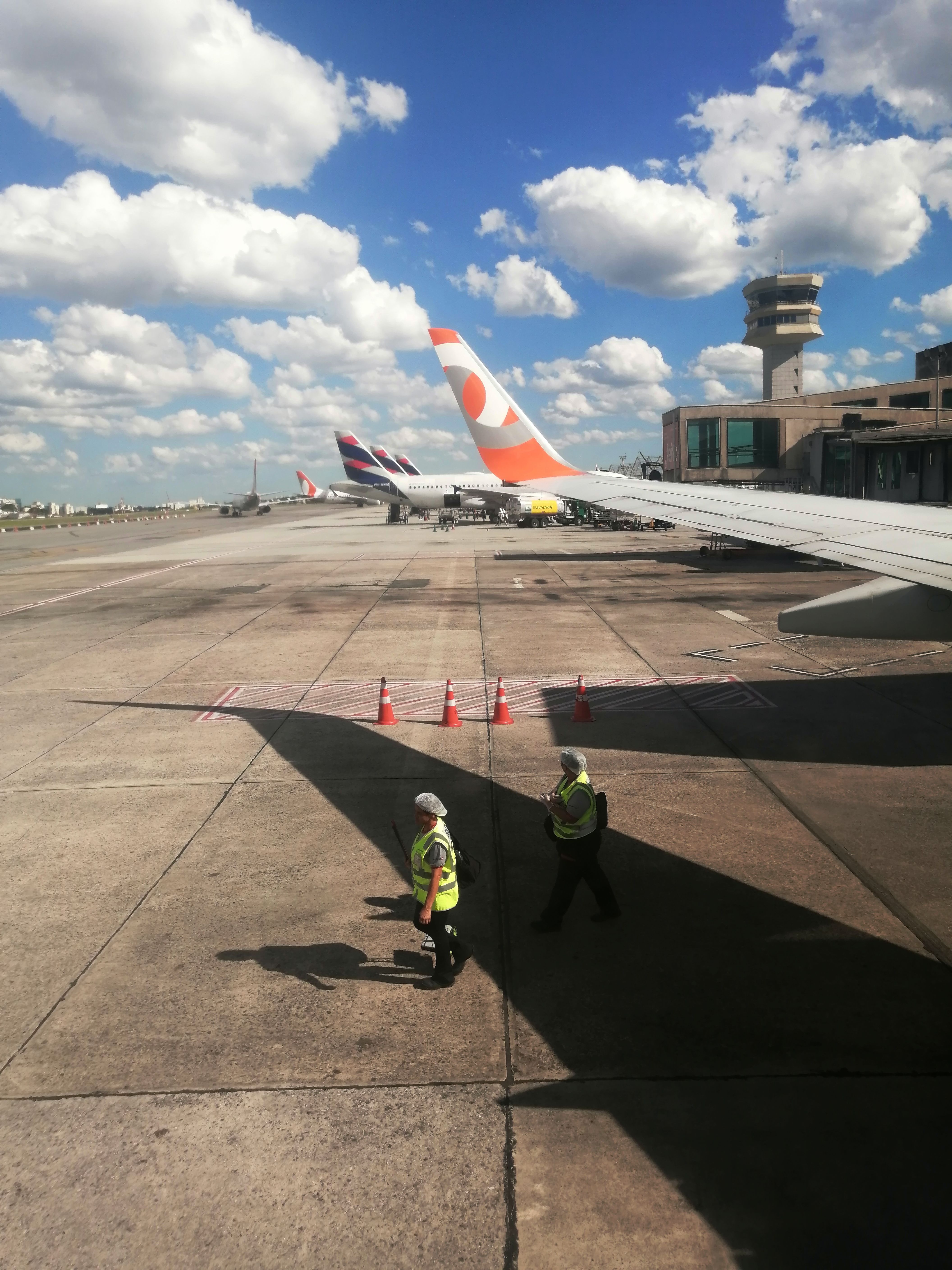 Operação aeroportuária com equipe de solo e torre de controle em São Paulo