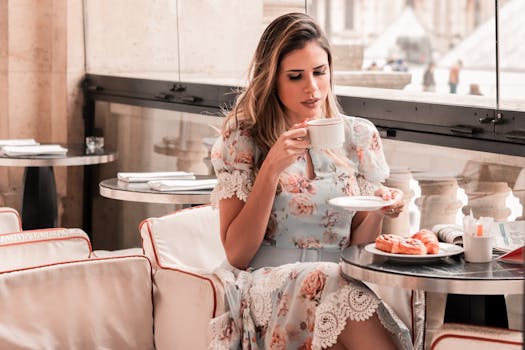 一位穿着花卉连衣裙的时尚女士正在高档咖啡馆里喝咖啡