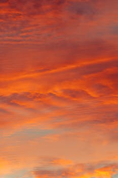 Capture the beauty of a vibrant sunset sky in Akumal, Quintana Roo, Mexico with warm hues and dramatic clouds.