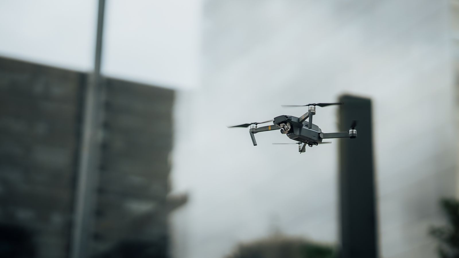 Close-up of a precision camera drone hovering in an urban sky