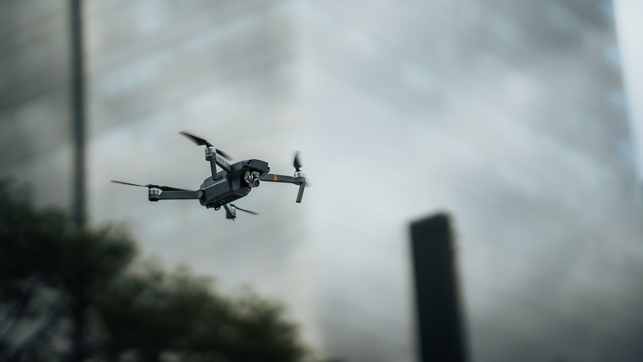 a drone hovering amidst tall buildings showcasing aerial technology in