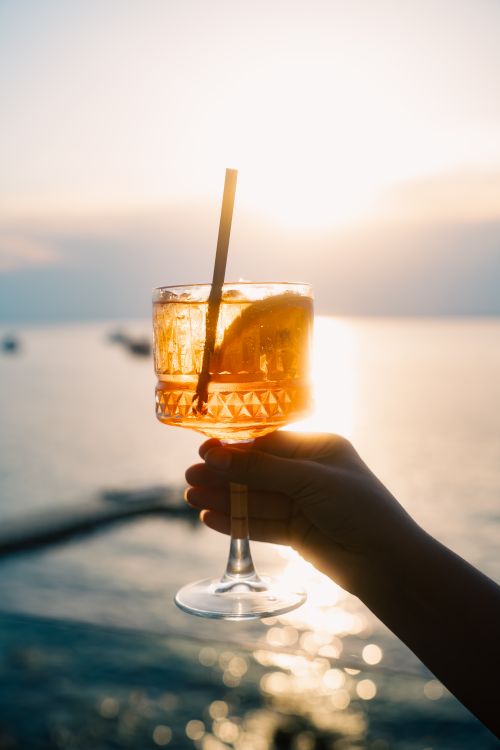 Free A vibrant cocktail held against a stunning Antalya sunset, capturing the essence of a perfect summer evening. Stock Photo