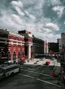 城市街景在多云天空下，以历史建筑和繁忙的交通为特色