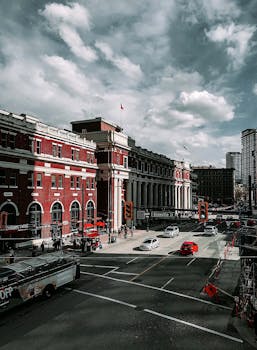 城市街景在多云天空下，以历史建筑和繁忙的交通为特色