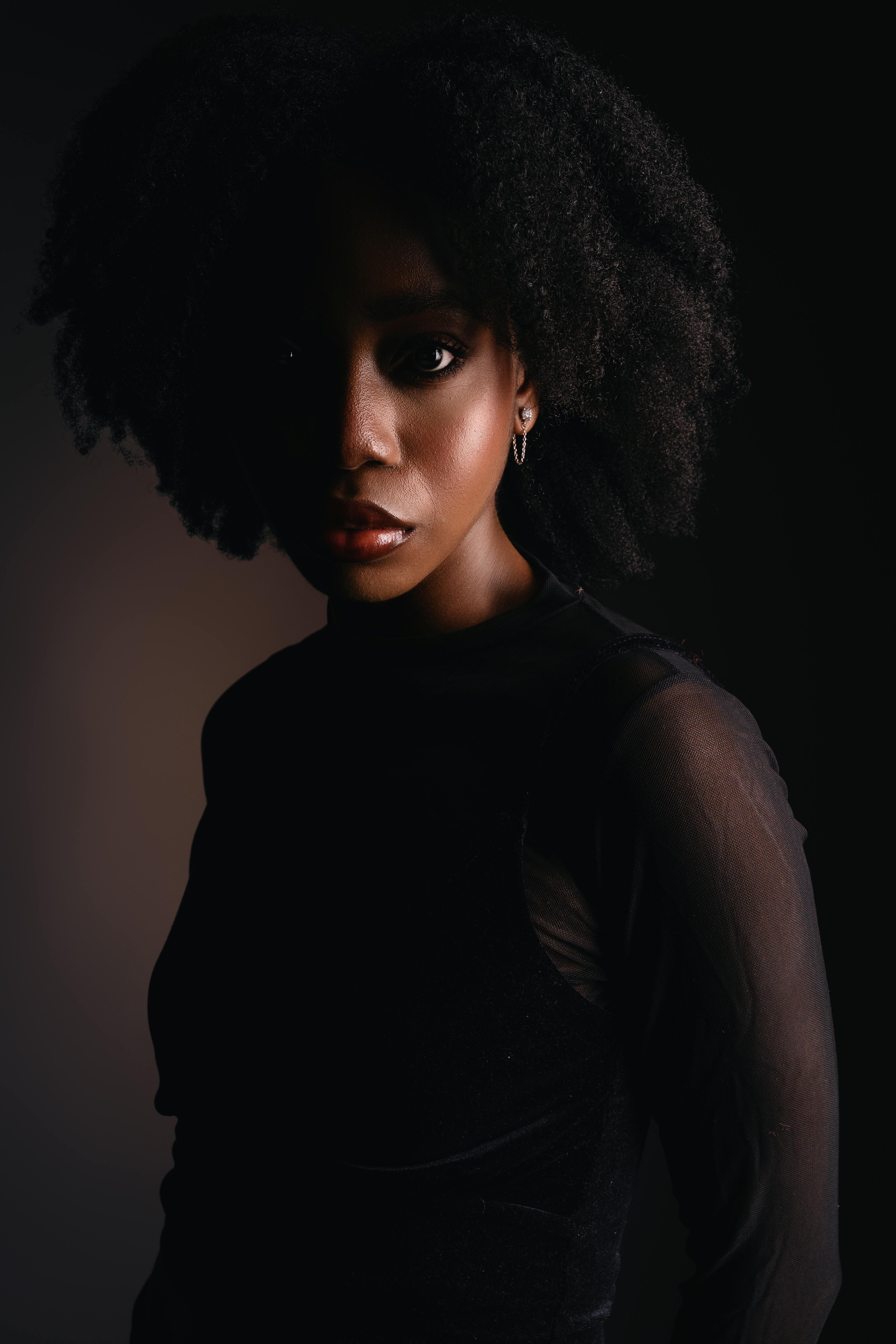 bezplatná Nápadná póza ženského modelu v tmavém, elegantním prostředí se studiovým osvětlením. Základová fotografie
