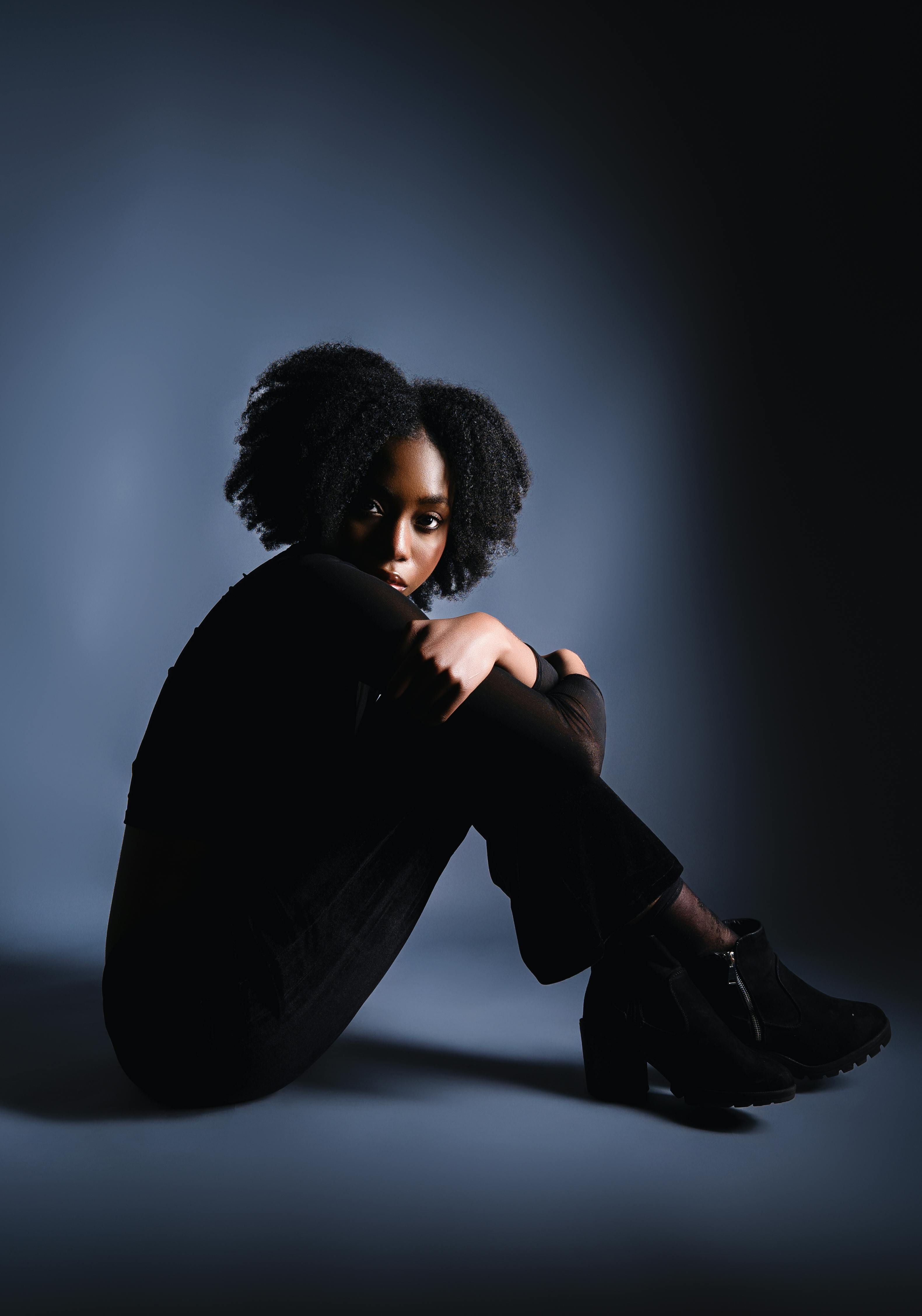 Bezpłatne Elegancki portret studyjny przedstawiający modelkę o wyrazistej pozie i nowoczesnym stylu. Zdjęcie z galerii