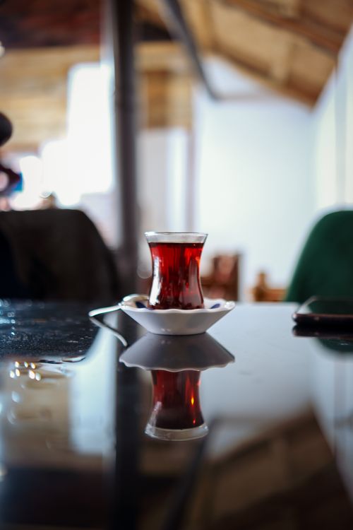 Free A warm indoor setting featuring a traditional Turkish tea glass on a reflective surface. Stock Photo