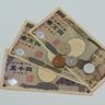 Close-up of Japanese yen banknotes and coins scattered across a flat surface.