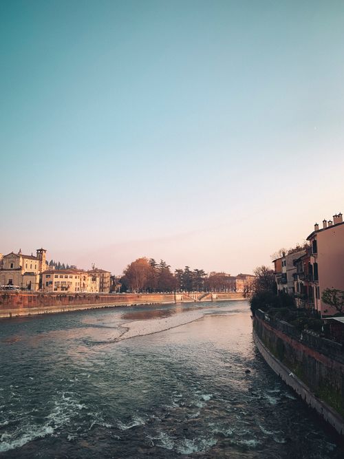 Free Captivating view of Verona's historic riverside architecture bathed in soft light. Stock Photo