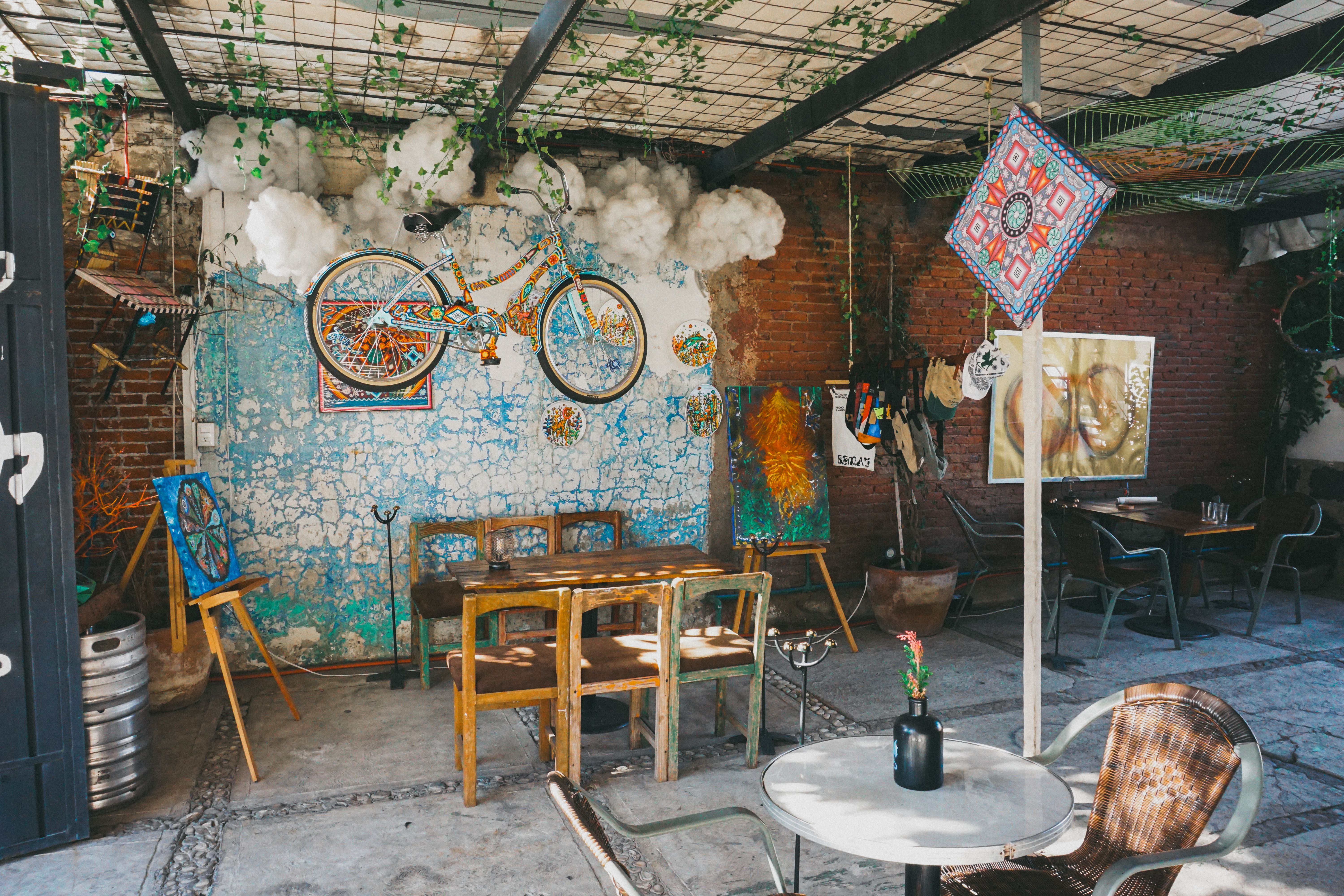 Eclectic cafe with colorful decor, mural art, and unique bicycle installation