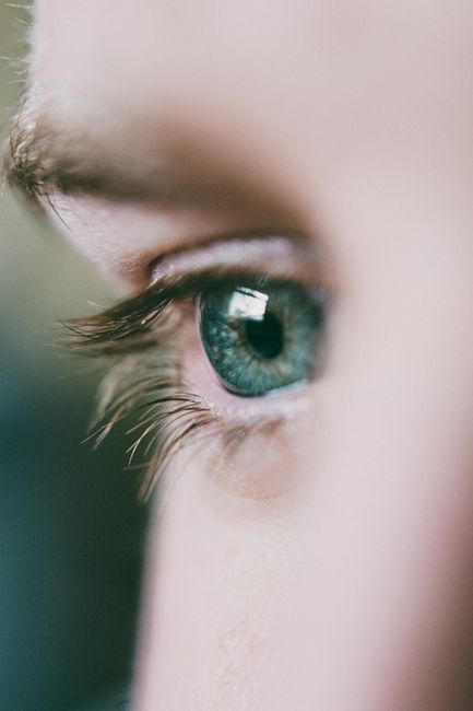 A detailed close-up shot of a blue eye showcasing eyelashes and eyebrows.