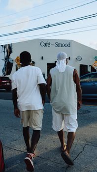 Two men walking outside Café Smood on a sunny day.