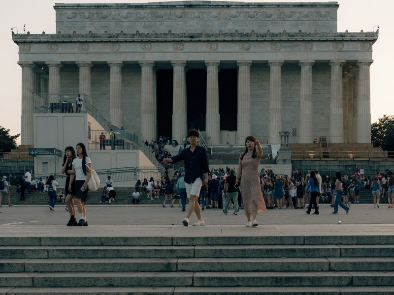 People exploring the steps of the iconic Lincoln Memorial at sunset - state tourism licensing