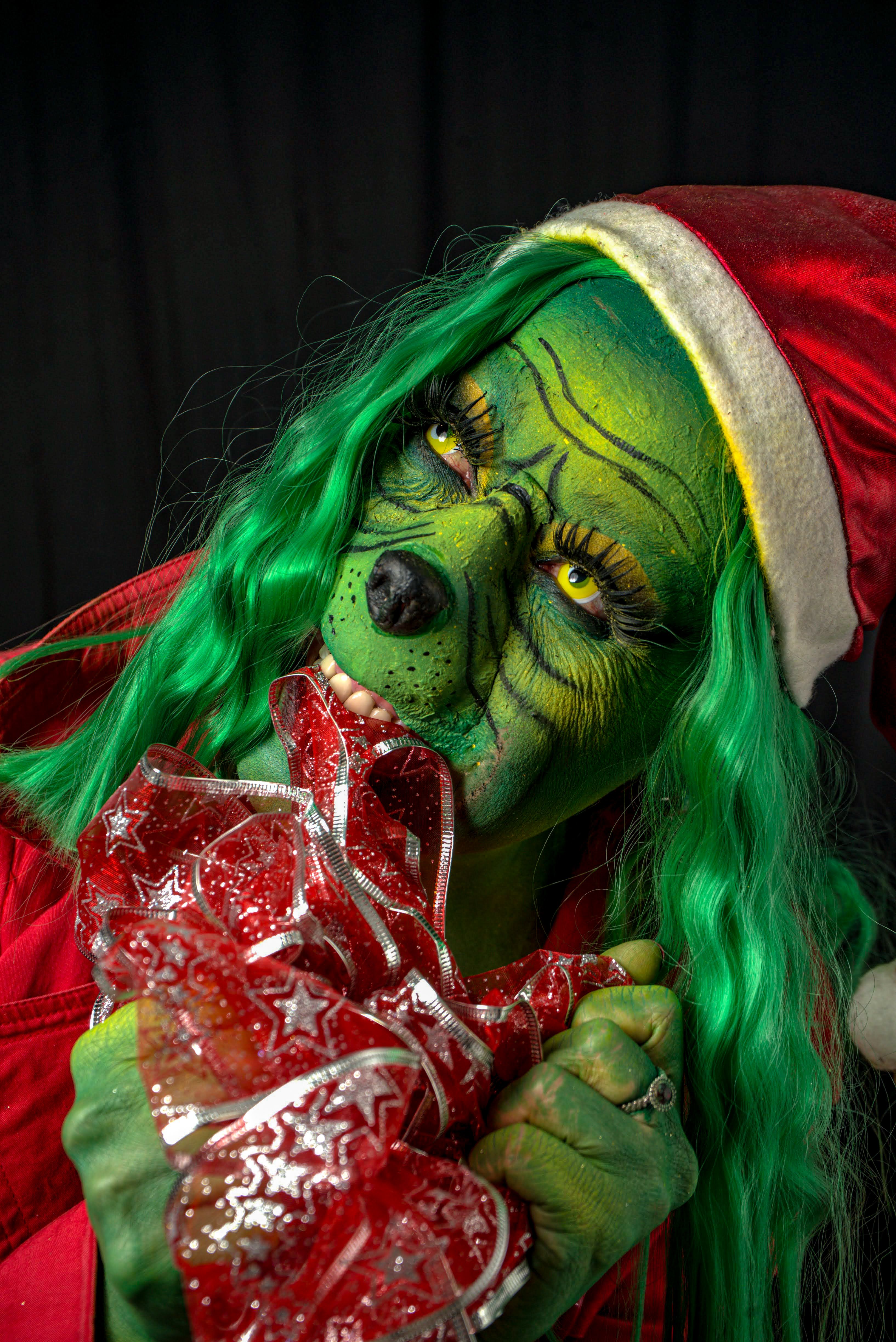 Colorful Grinch costume with Santa hat and festive holiday ribbon.