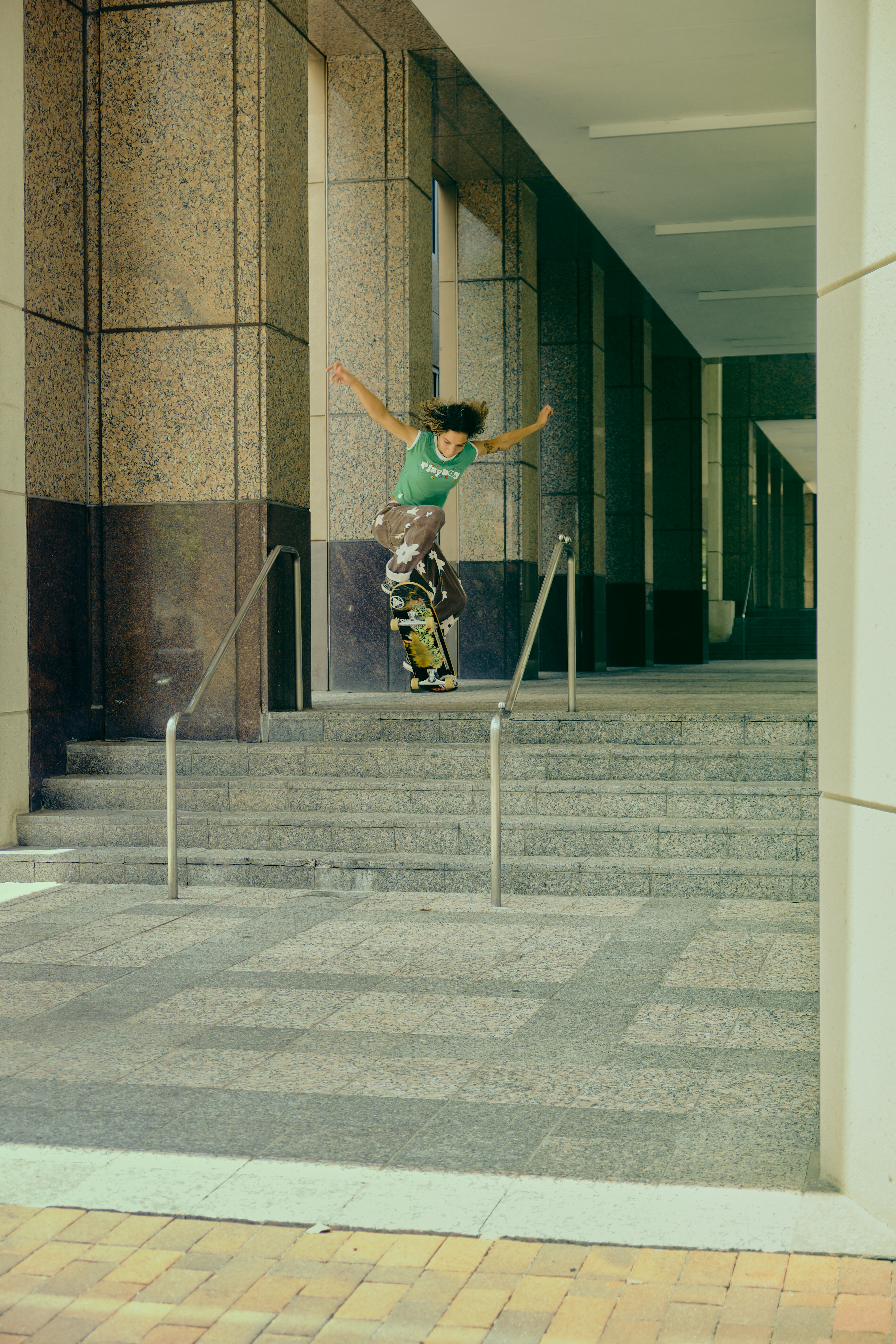 Skateboarder executing an ollie on urban concrete steps.