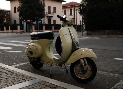 Classic Vespa parked on a serene street in Tuscany, capturing the charm of Italian urban life.