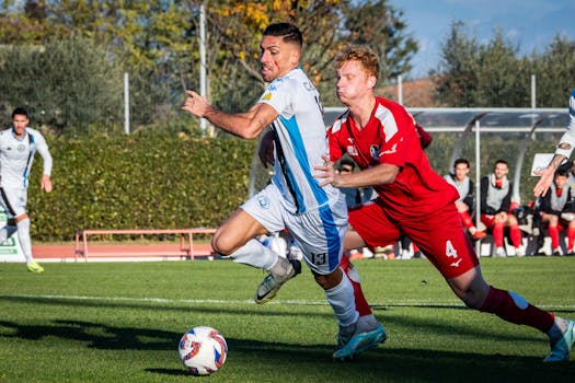 Dynamic action shot of soccer players competing in an outdoor match on a sunny day.