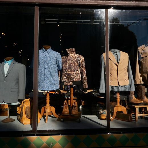 Menswear window display with branded shirts and casual wear