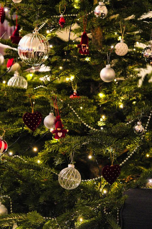 Free Beautifully decorated Christmas tree with lights and ornaments, capturing the festive spirit. Stock Photo
