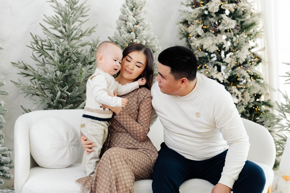 Photo by 21zere on Pexels Family enjoying a cozy winter moment indoors with decorative trees. - Photo by 21zere on Pexels