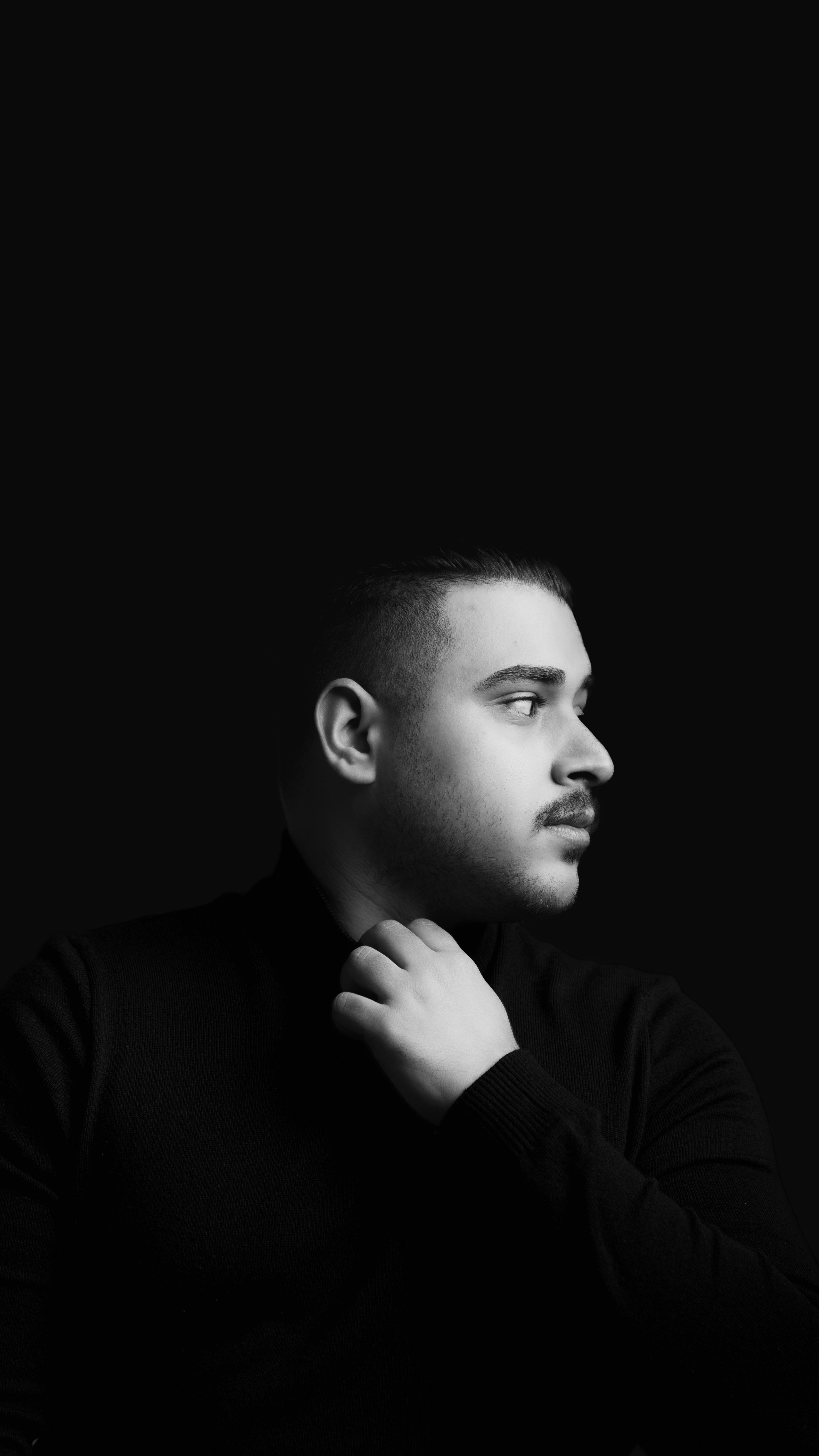 Black and white portrait of a man in profile view, looking contemplative.
