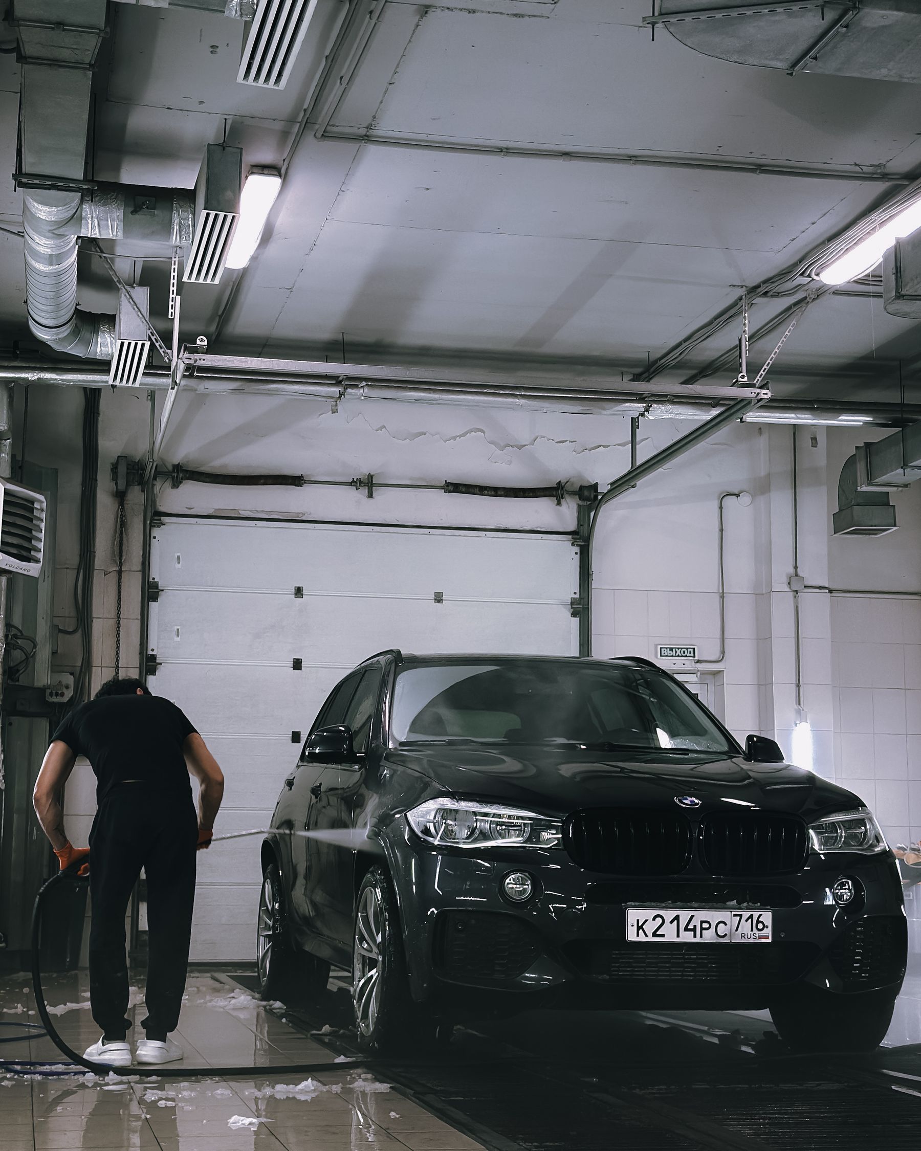 Professional car washing inside a real working garage