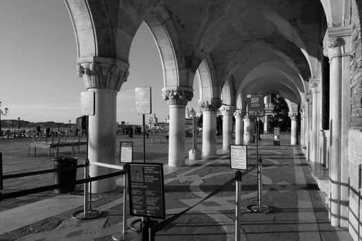 Black and white photo of arched columns at Doge's Palace, Venice, Italy.