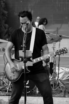 Musician playing electric guitar during outdoor street performance.