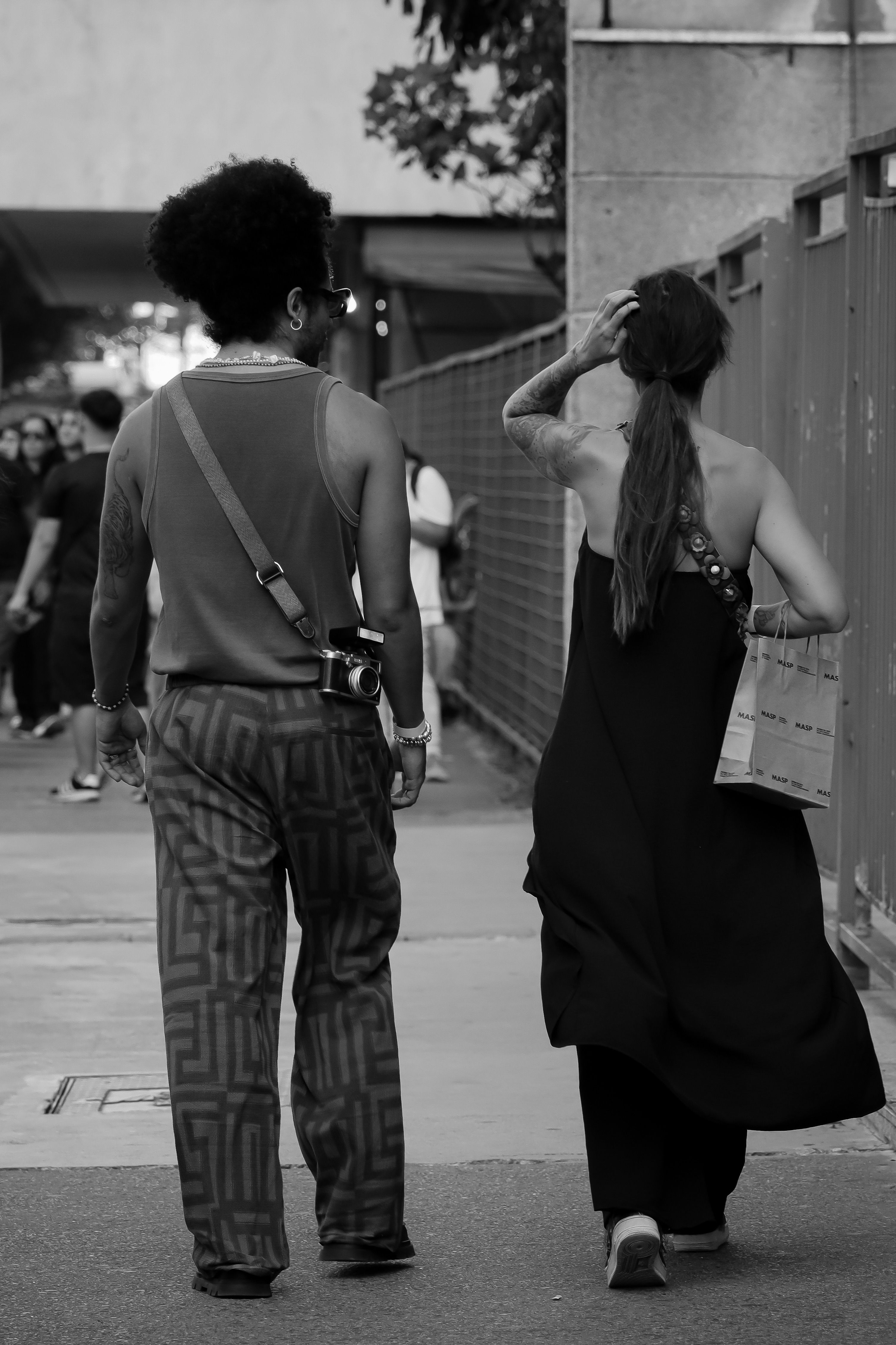 Monochrome image of a stylish couple walking in the city, showcasing urban fashion and lifestyle.