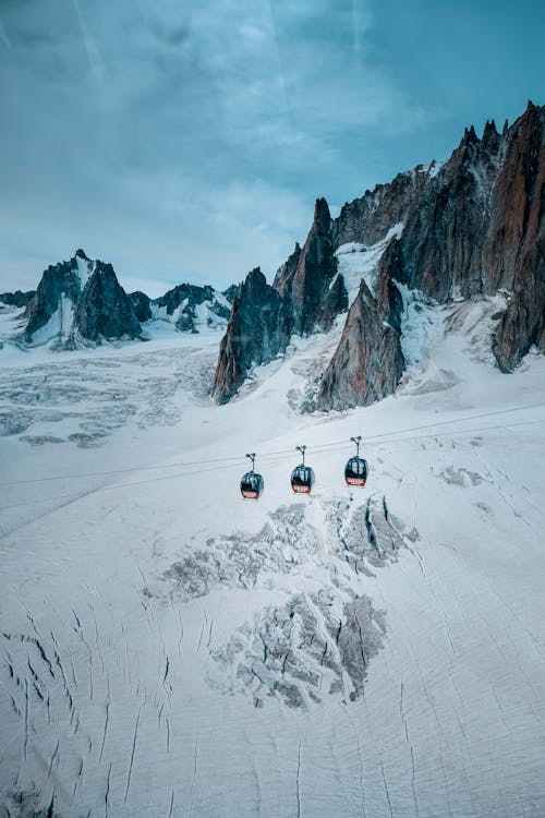 Three Cable Cars over Snow-covered Mountain