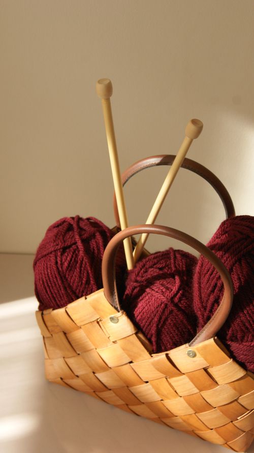 Free Warm sunlight on yarn and needles in a rustic basket, ideal for cozy craft themes. Stock Photo