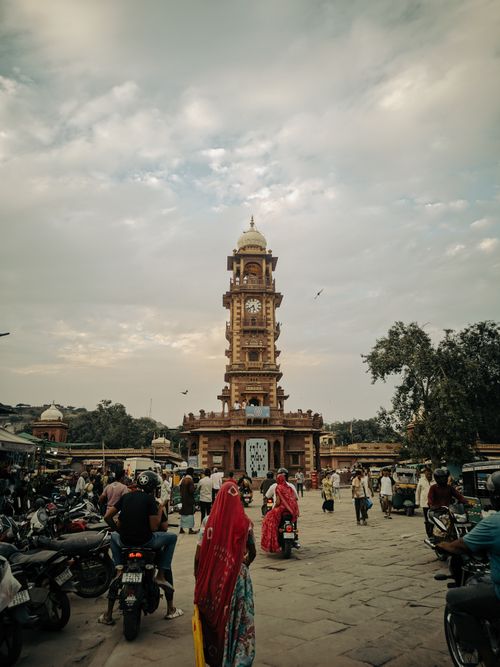 Free Bustling market scene at the iconic Clock Tower in Jodhpur, India with people and motorbikes. Stock Photo