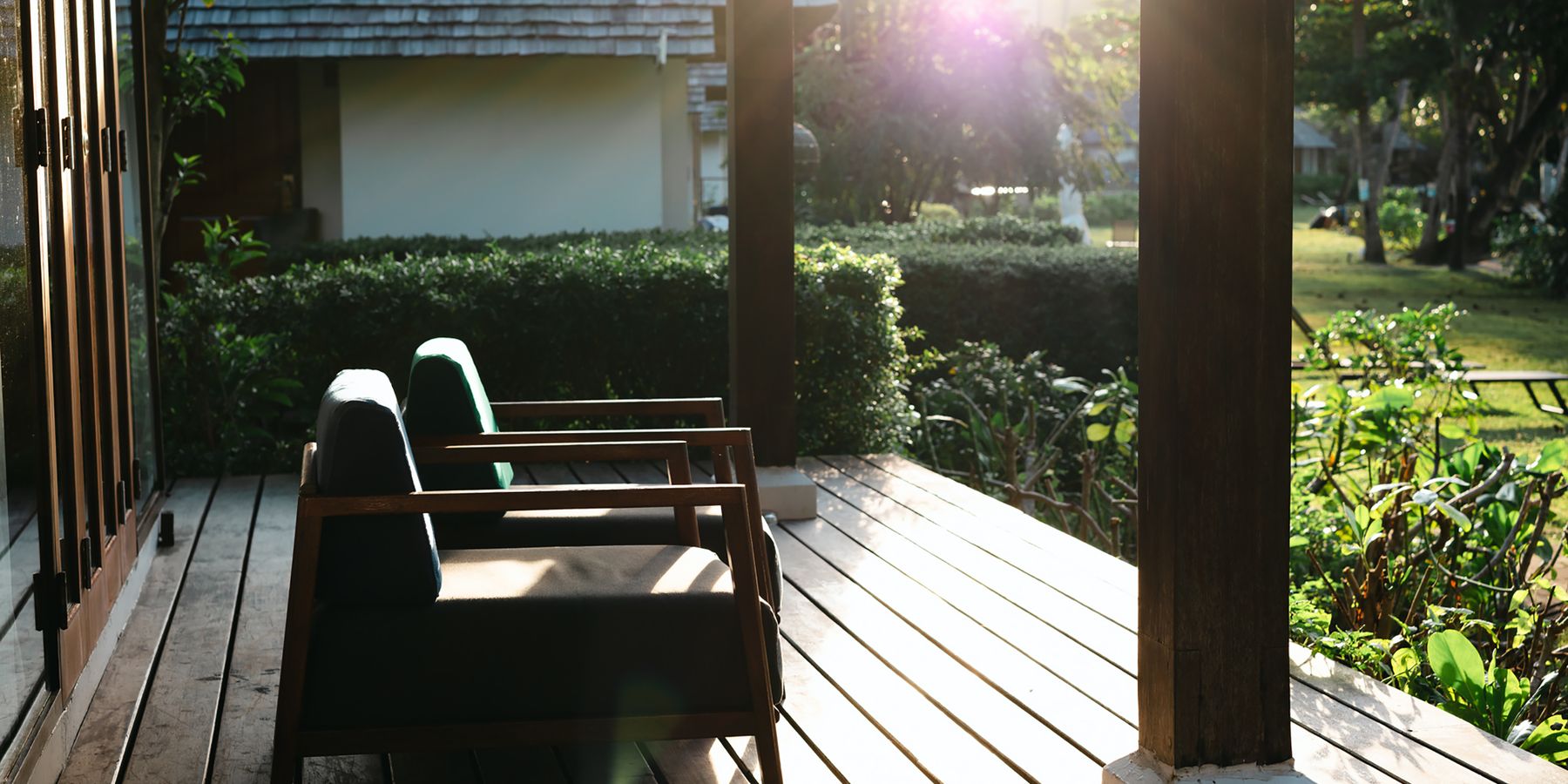 Outdoor patio with wooden furniture and lush greenery