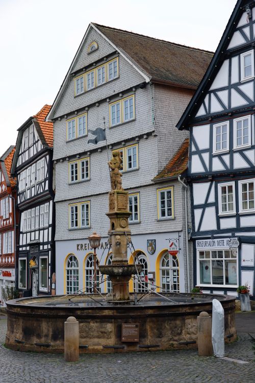 Free Charming view of historic timbered houses around a fountain in Fritzlar, Germany. Stock Photo