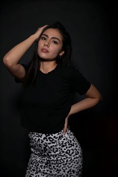Elegant portrait of a stylish young woman in a studio setting.