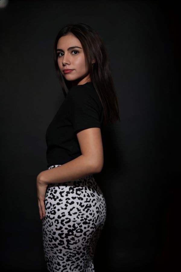 Elegant Woman in Black Top and Patterned Skirt · Free Stock Photo