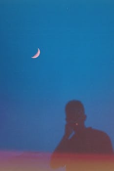 新月明亮，夜空下的人物剪影清晰可见