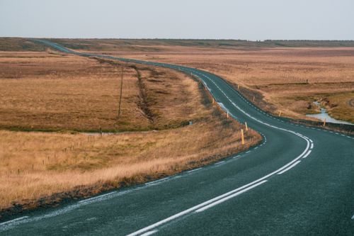 Free A scenic winding road through vast autumn plains under a clear sky, perfect for travel inspiration. Stock Photo