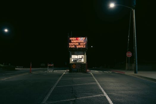 A high surf warning sign at night in Grover Beach, California. Atmospheric and moody lighting.