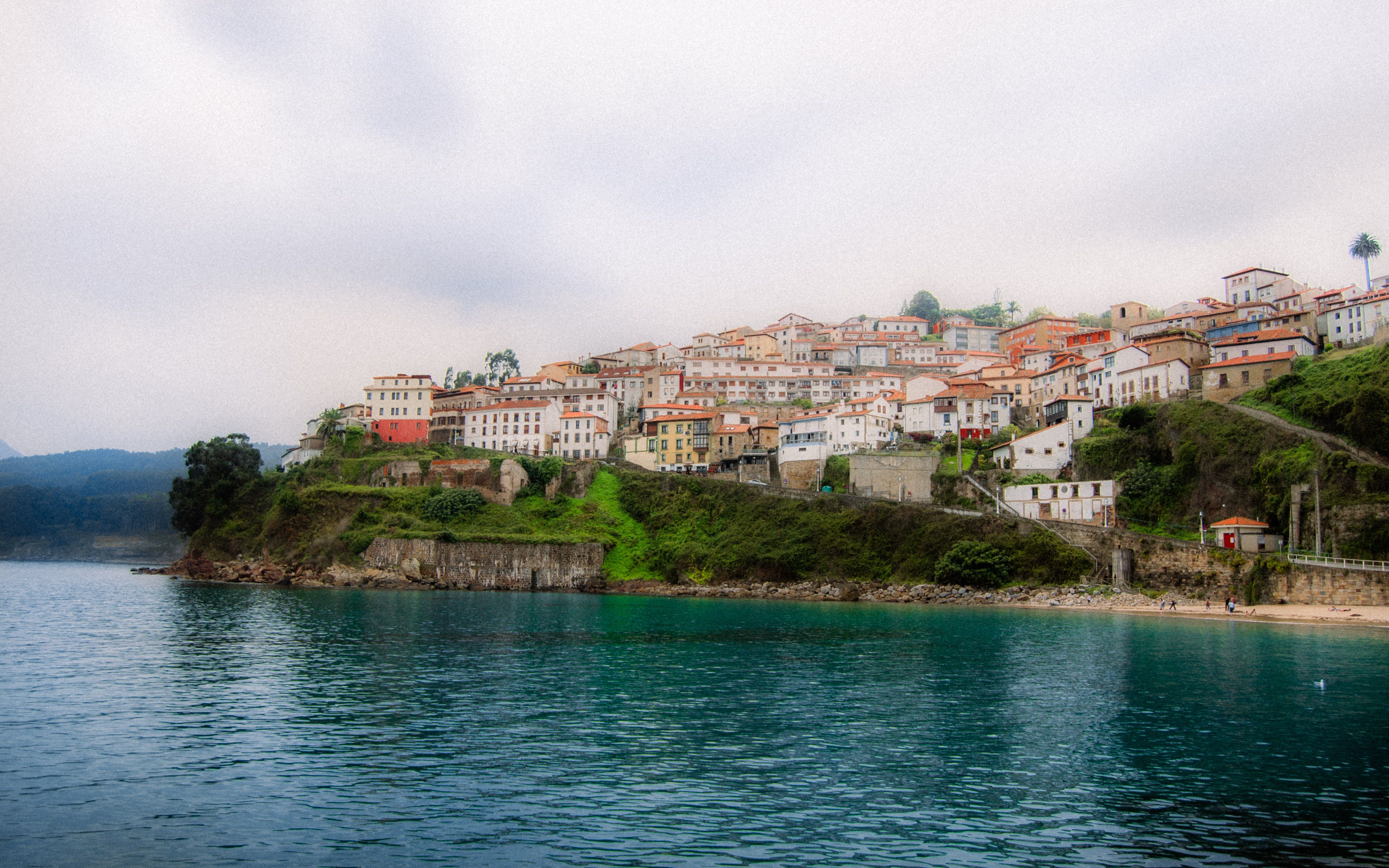 Fotomural Pintoresco pueblo costero de Asturias, España, con casas coloridas junto al mar.
