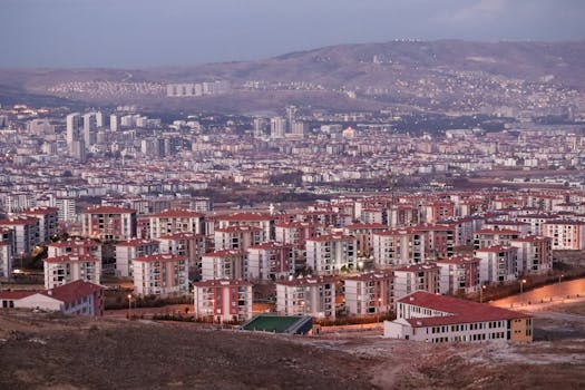 Aerial view of Elâzığ, Türkiye showcasing residential buildings and distant hills at dusk.
