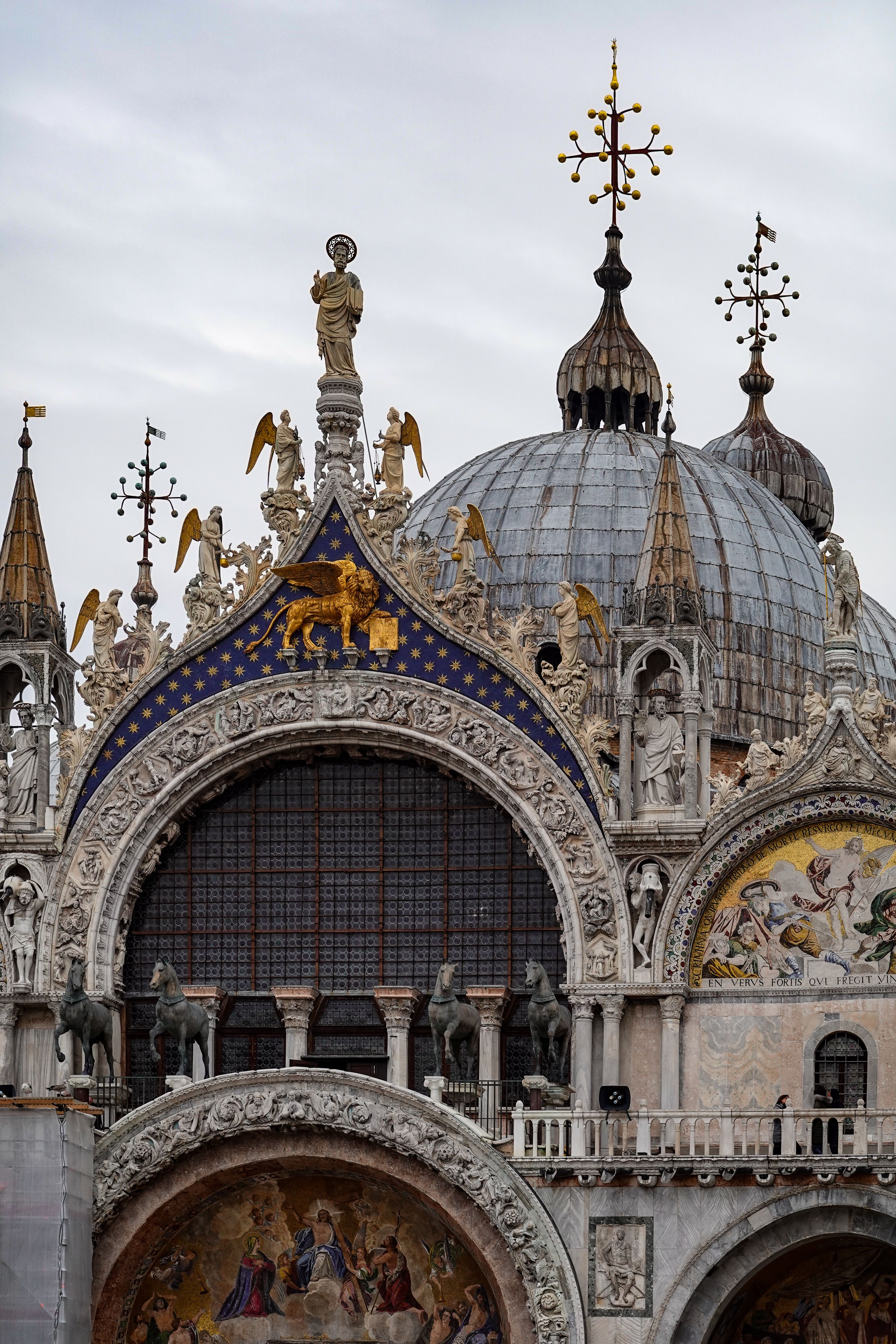 Close-up of the ornate facade of St. Mark's Basilica in Venice, showcasing detailed architectural work.