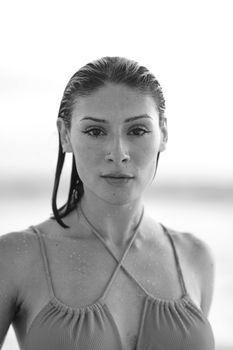 Black and white beach portrait of a young woman with wet hair in Los Angeles, CA.