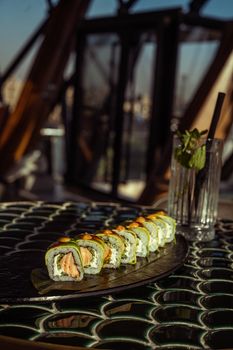Close-up of fresh sushi roll on a decorative table outdoors in Baghdad restaurant.