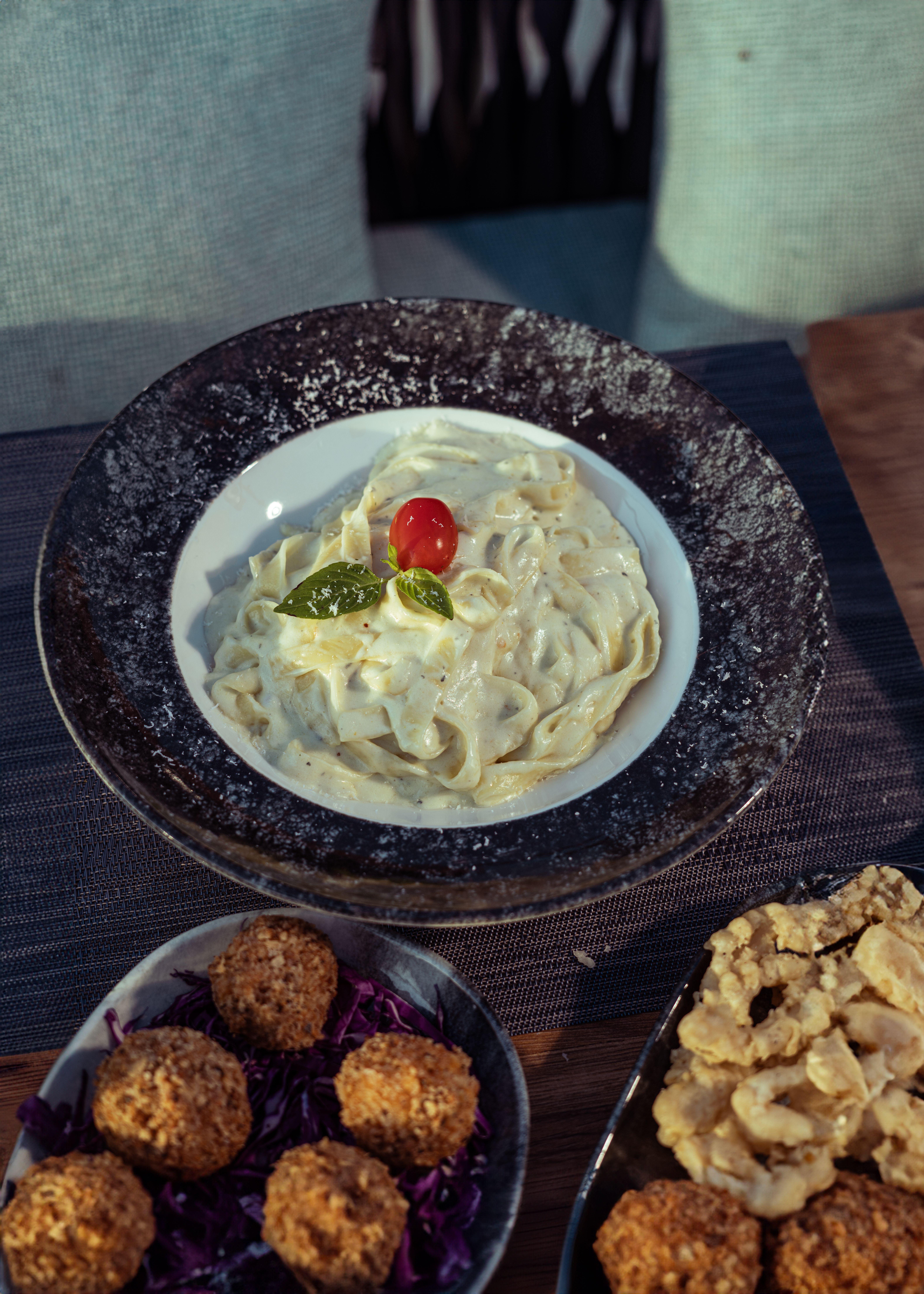 Delicious creamy pasta served with falafel and chicken sides, perfect for a hearty meal.