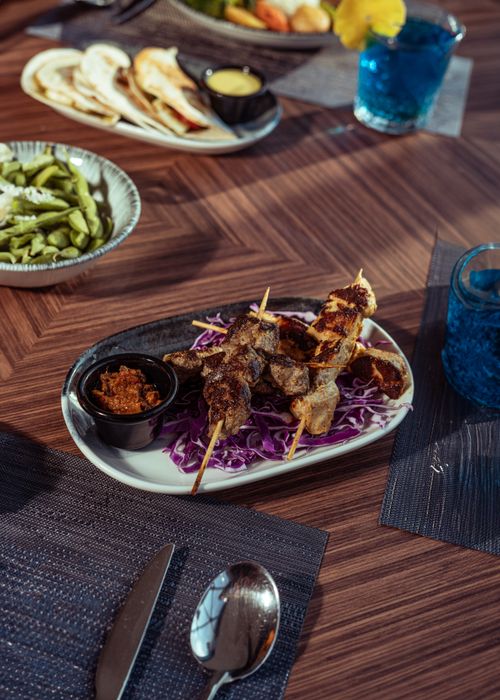 Free Grilled meat skewers with sauces and vegetables on a table setting in Baghdad. Stock Photo