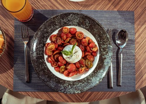 Free Top view of a Caprese salad with fresh mozzarella, cherry tomatoes, and basil served with juice. Stock Photo