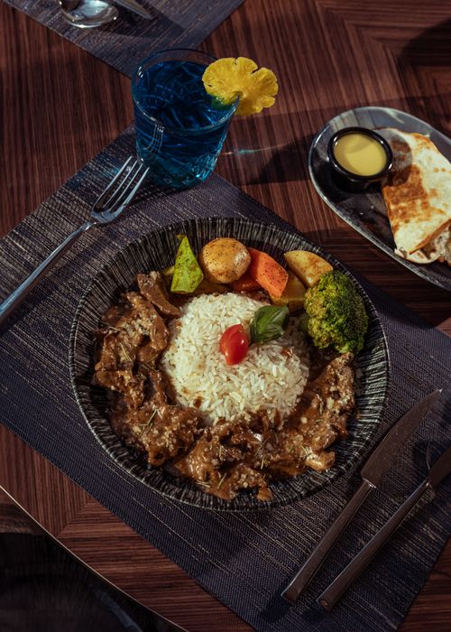 Free A mouth-watering meat dish with rice and vegetables, perfect for a hearty meal. Stock Photo