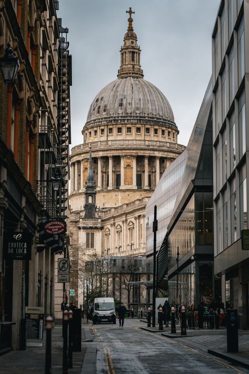 Free Street view of St. Paul's Cathedral, a stunning London landmark surrounded by architecture. Stock Photo